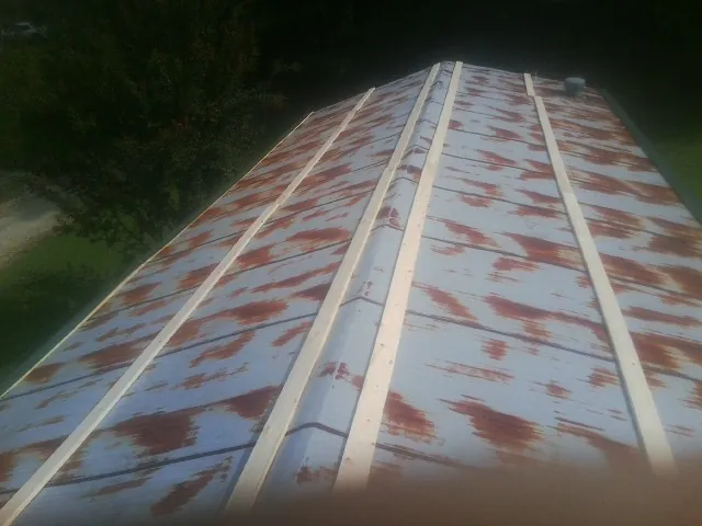 Rusted metal roof panels with new wood purlins before replacement — Storm Damage Roof Repair in Bedford Hills by Roofing Brothers
